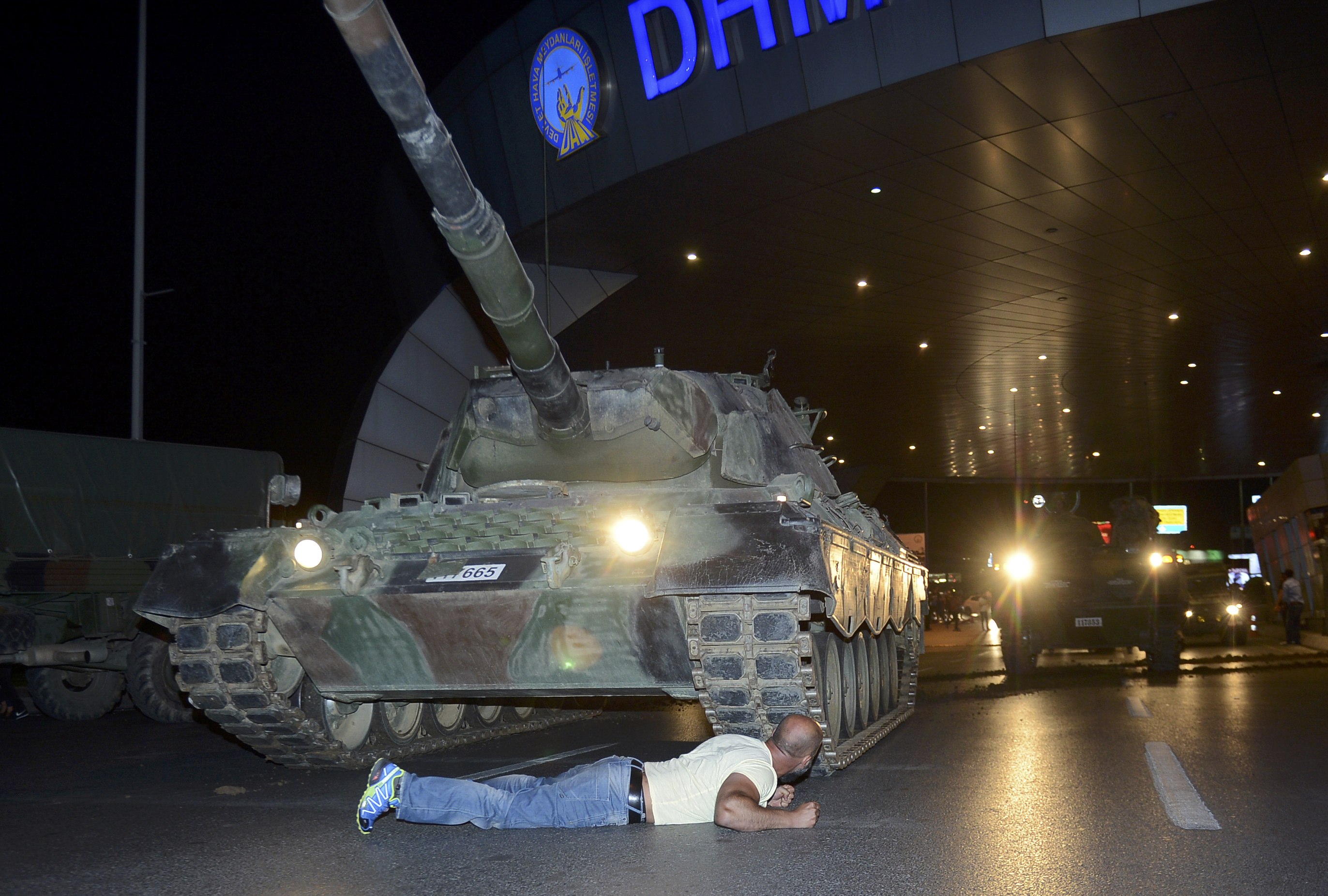 A man lies in front of a Turkish army tank at Ataturk airport in Istanbul, Turkey July 16, 2016. REUTERS/IHLAS News Agency NO SALES. NO ARCHIVES. TURKEY OUT. NO COMMERCIAL OR EDITORIAL SALES IN TURKEY.